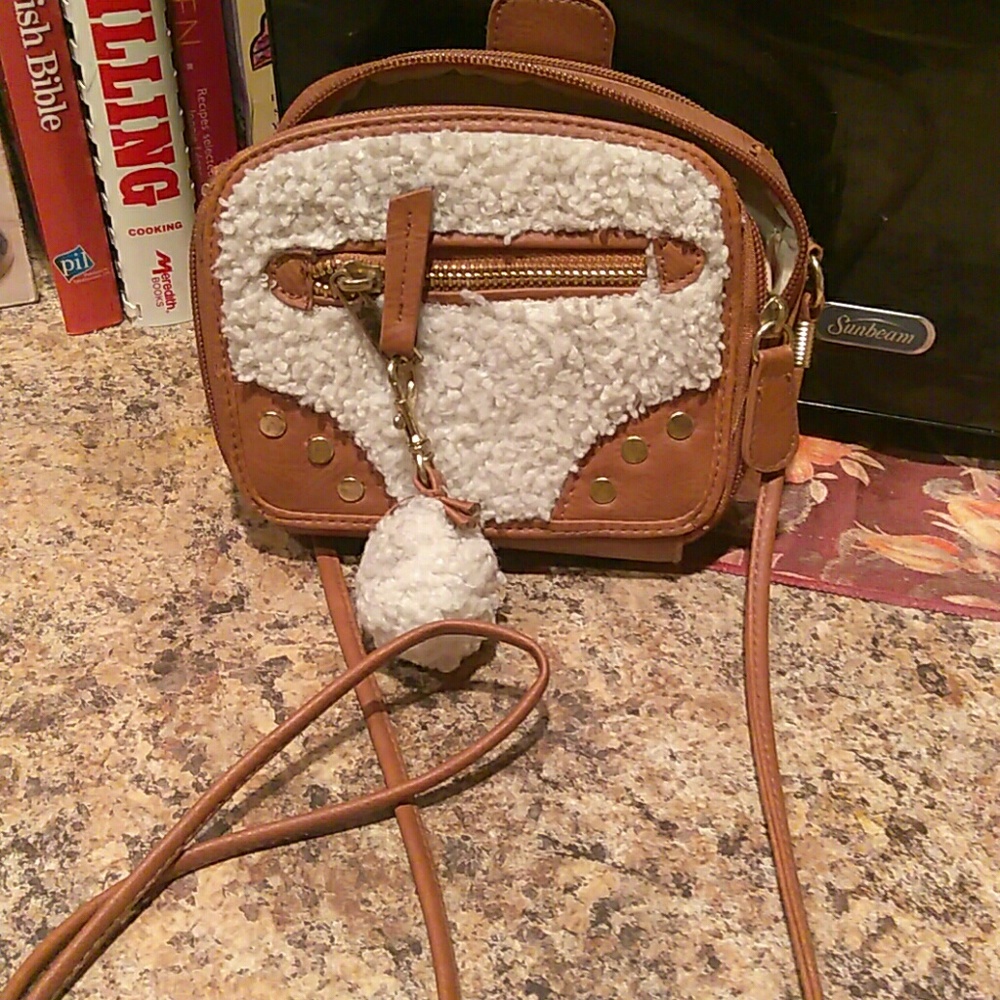 A brown bag with a fuzzy puff ball